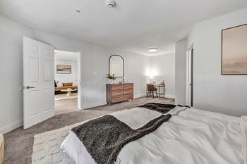 A bedroom with a large bed and a rug on the floor